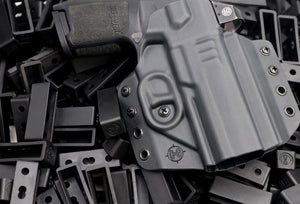 Decorative image of C&G OWB Kydex Holster holstering a Sig Sauer on top of many C&G OWB Belt loops. 